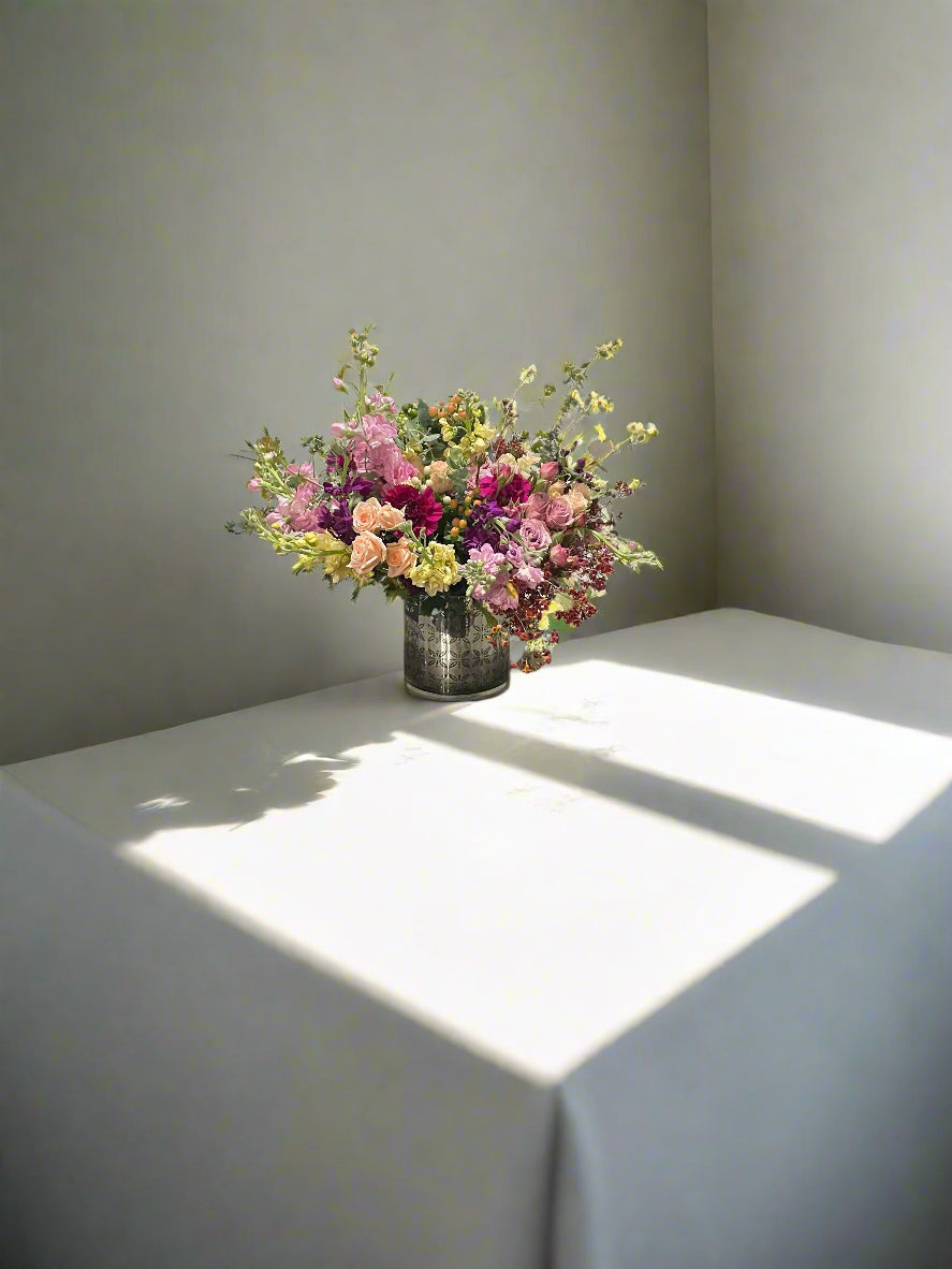 Bouquet of flowers on a table with sunlight casting shadows