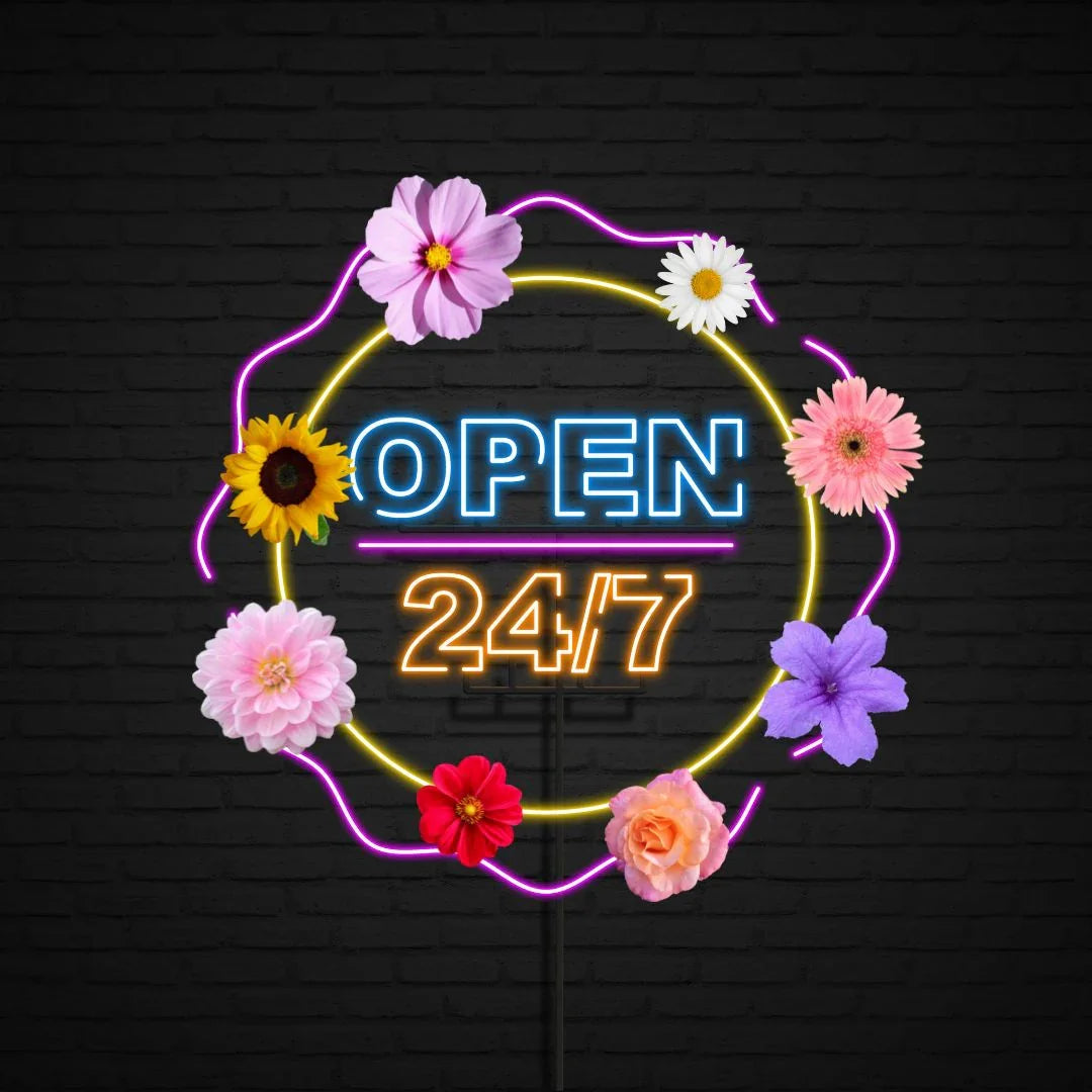 Bright neon sign saying OPEN 24/7 surrounded by colorful fresh flowers on dark wall