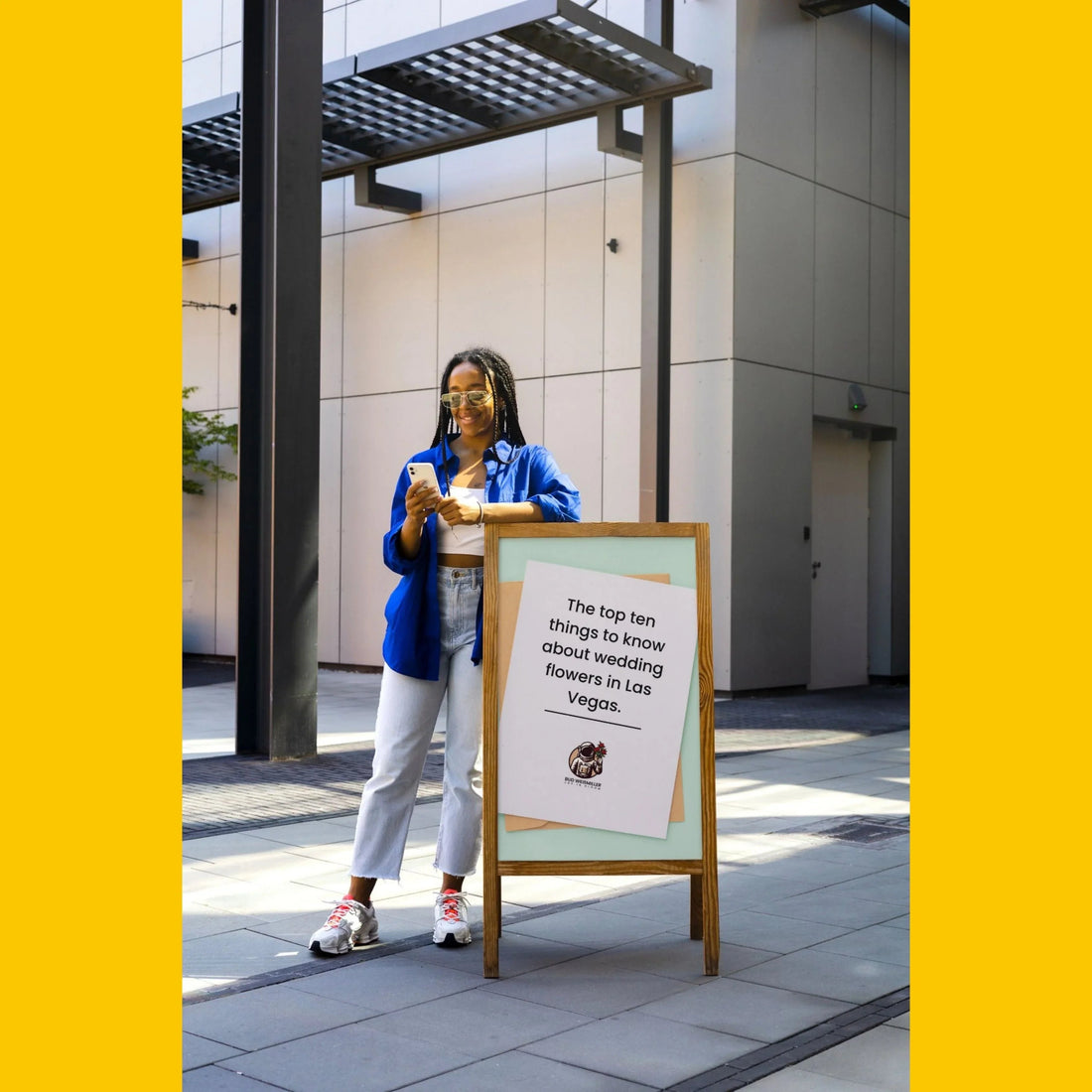 Smiling woman in blue shirt reading about top wedding flowers in Las Vegas on city sidewalk