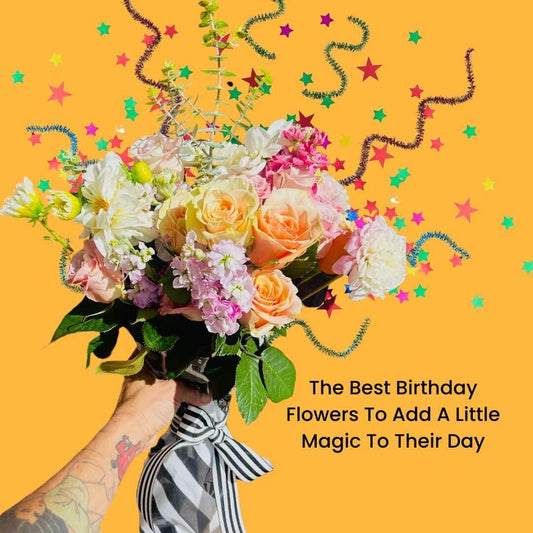 Hand holding colorful birthday bouquet with roses, white and pink flowers, and festive star confetti