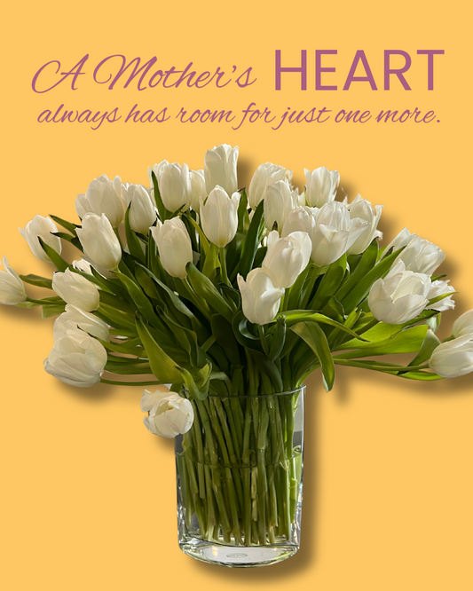A beautiful bouquet of white tulips in a clear glass vase.