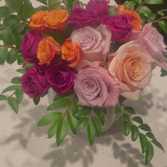 A video of Bud Weismiller's Pumpkin Spice and Everything Nice Bouquet featuring pink and peach roses, burnt orange and fuchsia spray roses, and seasonal greenery all artfully arranged in a pumpkin vase.