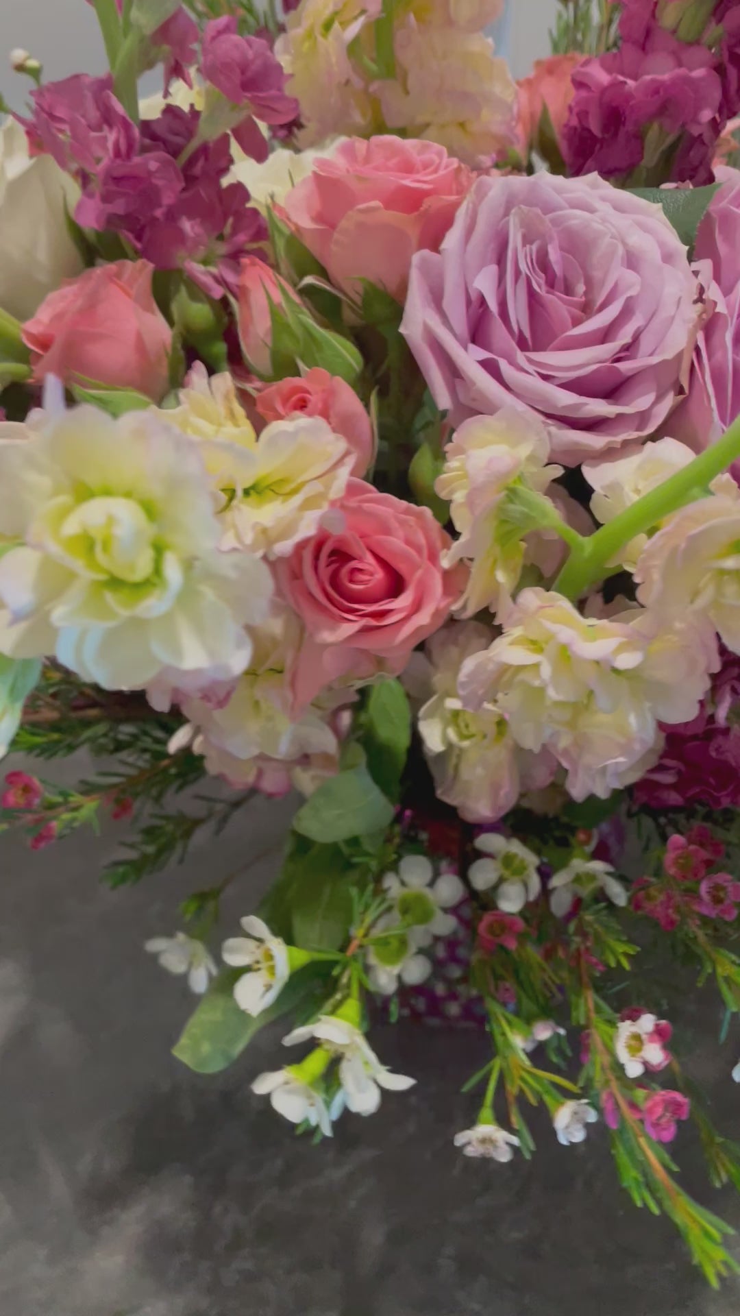 A beautiful bouquet featuring pink roses, snapdragons, stock flowers, and wax flowers in a unique upcycled vase, perfect for any occasion.